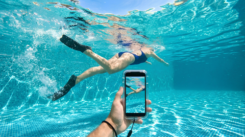 Smartphone filmant sous l'eau en mer pour créer du contenu social media estival sur TikTok et Instagram.